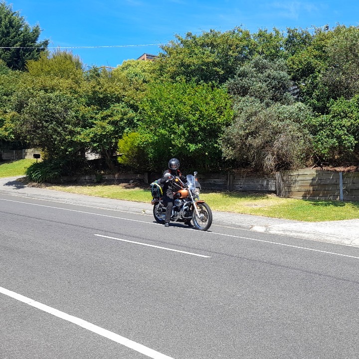 myself on my motorcycle harley davidson 2008 sportster custom 1200cc loaded with bags riding down the road