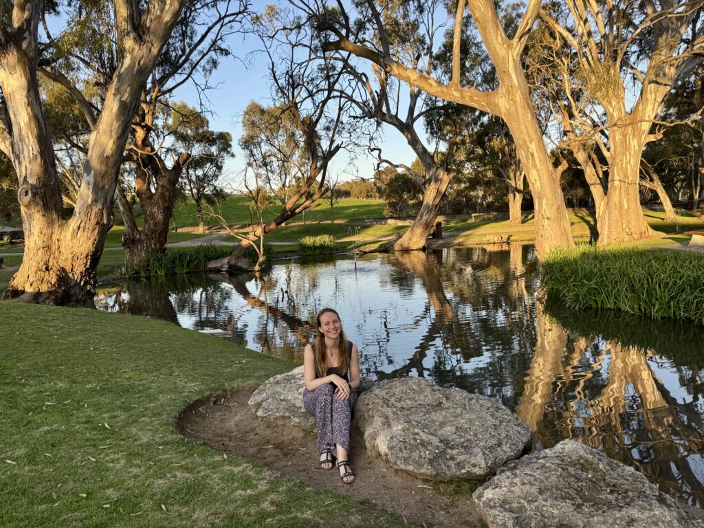 girl in border town by lake stopping for a stretch break after travelling and experiencing lots of travel mishaps