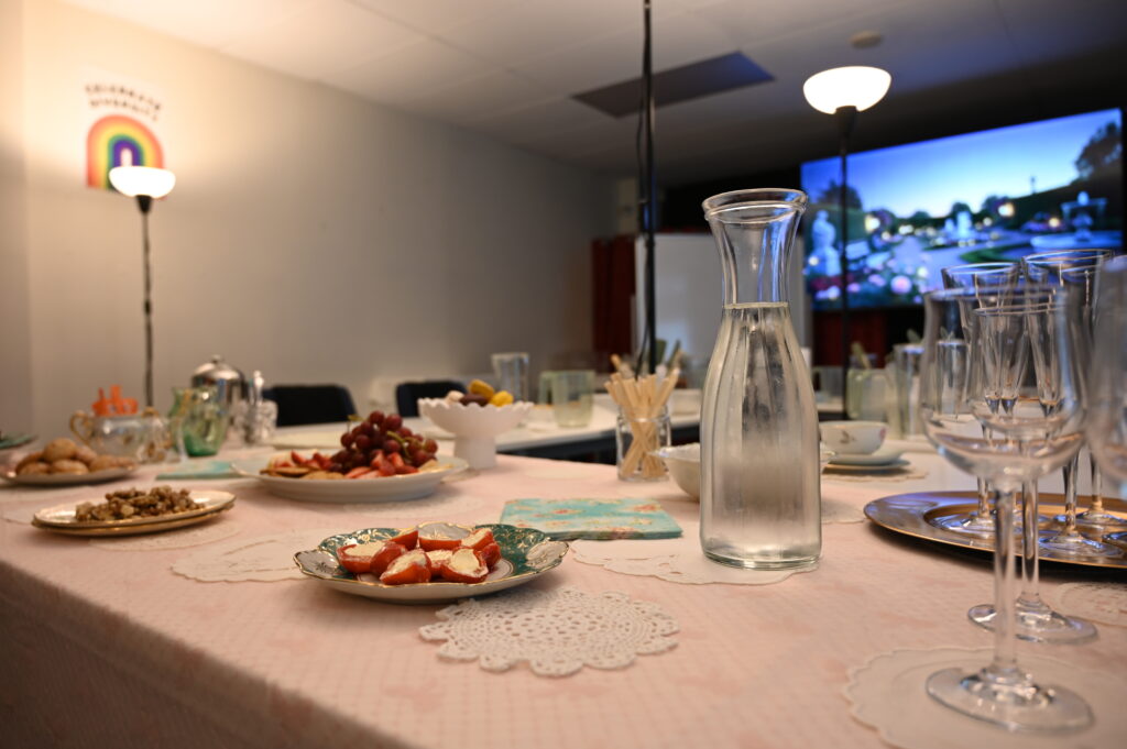 Wide shot of the sensory-friendly workroom set up for the workshop, with soft lighting, tables with decorating supplies, and a pretty supper laid out.
