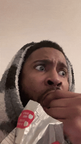 Guy eating popcorn frantically mirroring the idea of watching 16 movies in a day