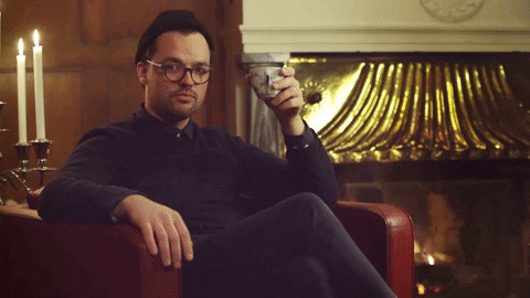 Person on chair in front of fire saying "Quite simple really, you just do it"